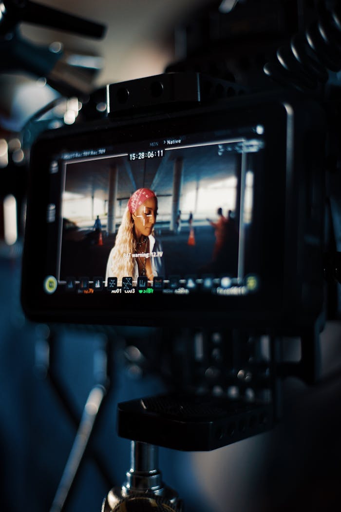 Close-up of a camera monitor showing a film scene with a blonde woman on set.